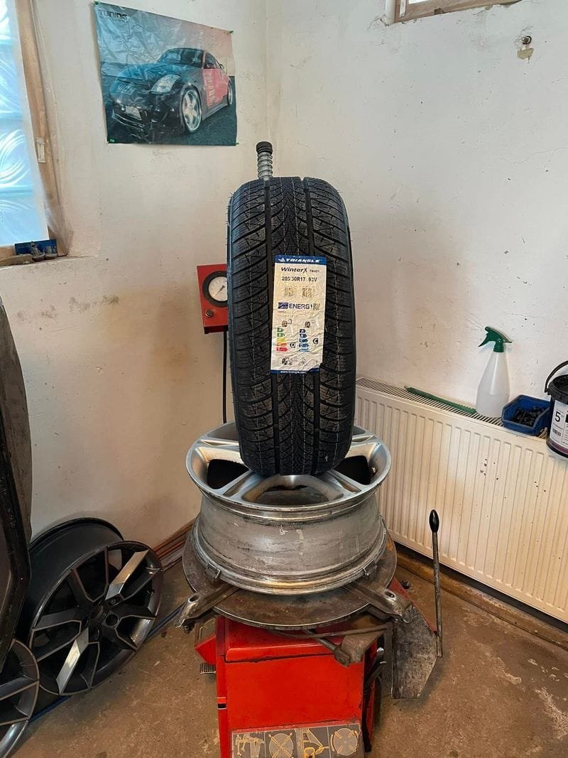 Vadonatúj téli gumi címkével az alufelnin, a szerelőgépen