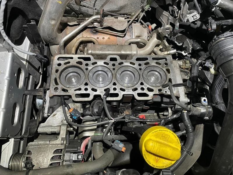 Motorblokk a lehúzott hengerfej alatt, a régi fejtömítéssel, csere közben